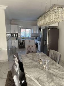 a kitchen with a table with wine glasses on it at Luxury 2 bedroom flat KerrSerign in Bathurst