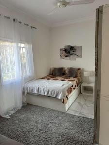 a white bedroom with a bed and a window at Luxury 2 bedroom flat KerrSerign in Bathurst