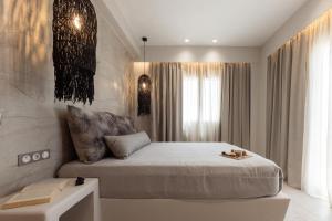 a bedroom with a king sized bed and a table at Villa Finest -Seaside Villa with private swimming pool at Orkos in Mikri Vigla
