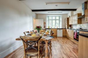 cocina con mesa de madera y sillas en The Bladon Farmhouse en Woodstock