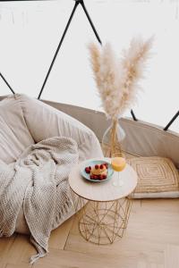 a table with a plate of food and a glass of orange juice at Czorsztyn Glamp in Maniowy +60 photos