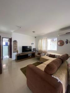 ein großes Wohnzimmer mit Sofa und TV in der Unterkunft Casa Blue Horse Pipa in Pipa