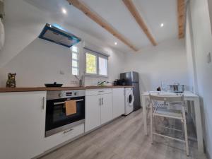 a kitchen with a stove and a sink and a table at Le Rawai in Fos-sur-Mer