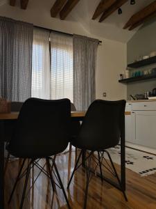 twee zwarte stoelen aan een tafel in een keuken bij Apartman Park in Zlatibor