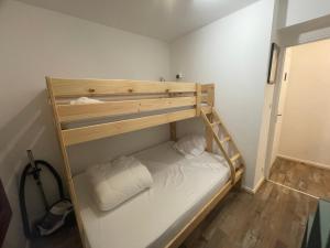 a bunk bed with two white pillows in a room at Résidence La Ruche-Appartement ISOARD (T2) in Les Carroz d'Araches