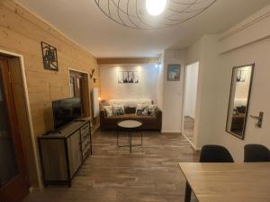 a living room with a bed and a flat screen tv at Résidence La Ruche-Appartement ISOARD (T2) in Les Carroz d'Araches