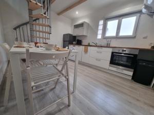 a kitchen with a white table and a chair at LE CHALONG in Fos-sur-Mer