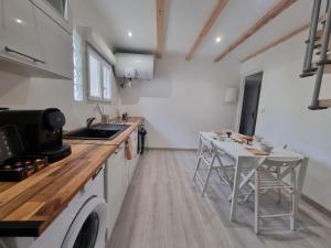 a kitchen with a sink and a table with chairs at LE CHALONG in Fos-sur-Mer