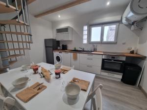 a kitchen with a white table and a white counter top at LE CHALONG in Fos-sur-Mer +3 photos