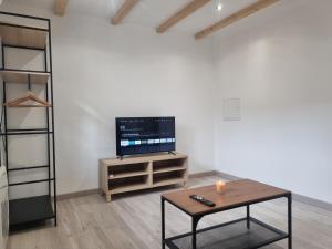 a living room with a tv and a coffee table at LE CHALONG in Fos-sur-Mer