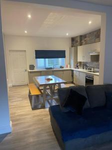 a living room with a couch and a table in a kitchen at Oyster Retreat in Amble +11 photos