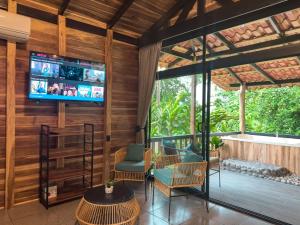 a living room with wooden walls and a flat screen tv at Green Forest Villa in Fortuna