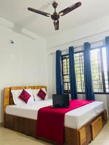 a bedroom with a bed with a laptop on it at Green Line Homestay in Vythiri