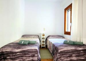 2 camas individuais num quarto com uma janela em Casa con piscina en Tortosa Delta de l'Ebre em Tortosa