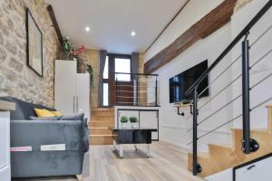 uma sala de estar com um sofá e uma escada em Clara - Modern Loft Sorbonne Notre-Dame Historic em Paris