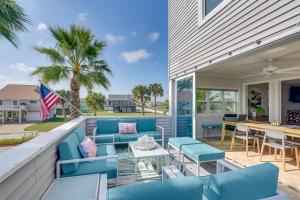 an outdoor patio with blue chairs and a table at Luxury Galveston Retreat - Walk to Pirates Beach! in Galveston