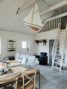 a living room with a white couch and a staircase at Litet hus i mysig by nära havet in Ystad +16 photos