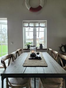 uma mesa de jantar com cadeiras e uma vela em Litet hus i mysig by nära havet em Ystad
