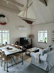sala de estar con mesa, sillas y TV en Litet hus i mysig by nära havet en Ystad
