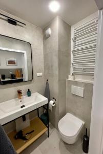 een badkamer met een wit toilet en een wastafel bij Plac Wolności 6 in Poznań