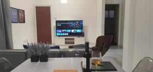 a room with a table with a bottle of wine and a tv at BLUE LUXURY APARTMENT (BREAKBOOKING CY-SERVICES LTD) in Limassol