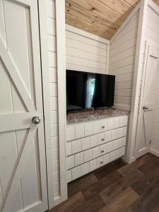 a tv sitting on a cabinet in a room at 4 Heron Haus, Luxury Tiny House, Pet Friendly, Mins to Downtown Guntersville in Guntersville