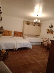 a bedroom with two beds and a tiled floor at Cortijo Paulenca in Almería