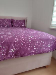 - un lit violet avec une couette et des oreillers en violet dans l'établissement Apartman Behar Otoka Sarajevo, à Sarajevo