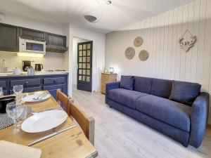ein Wohnzimmer mit einem blauen Sofa und einem Tisch in der Unterkunft Appartement Saint-Martin-de-Belleville, 2 pièces, 4 personnes - FR-1-344-1020 in Saint-Martin-de-Belleville