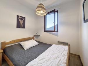 Schlafzimmer mit einem Bett und einem Fenster in der Unterkunft Appartement Saint-Martin-de-Belleville, 2 pièces, 4 personnes - FR-1-344-1020 in Saint-Martin-de-Belleville