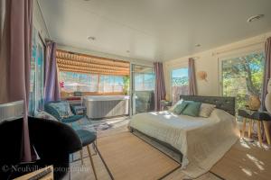 a bedroom with a bed and a bathroom with a tub at L'Oustaou du Luberon et SPA in Villelaure