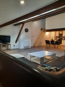 ein Wohnzimmer mit einem Sofa und einem Tisch in der Unterkunft Les Charmes de Trévoux in Trévoux