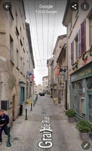 an empty street in a city with buildings at Les Charmes de Trévoux in Trévoux