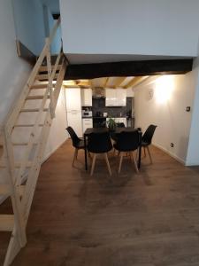 a dining room with a table and chairs and a staircase at Les Charmes de Trévoux in Trévoux