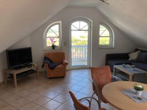 a living room with a couch and a tv at Ferienwohnung Graswald mit Panoramablick in die Rhön in Kaltennordheim