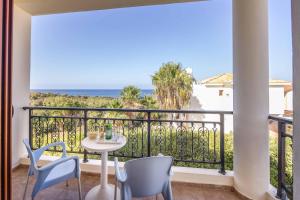a balcony with a table and chairs and the ocean at Villa Marilia in Neo Chorio