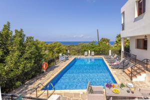 a swimming pool with a view of the ocean at Villa Marilia in Neo Chorio