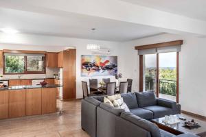 a living room with a couch and a kitchen at Villa Marilia in Neo Chorio