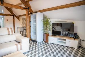 a living room with a white couch and a tv at Guest House - Palácio Diana in Évora