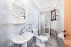 a bathroom with a sink and a toilet and a mirror at Villa Marilia in Neo Chorio +29 photos