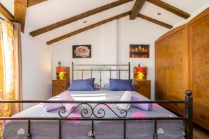 una camera da letto con letto in metallo e cuscini viola di Holiday Home Svjetlana a Risika