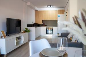 ein Wohnzimmer mit einem Sofa und einem TV sowie eine Küche in der Unterkunft O Son in Porto do Son