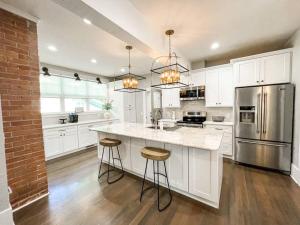 eine Küche mit weißen Schränken und Küchengeräten aus Edelstahl in der Unterkunft Stunning remodeled Downtown dream home! in Colorado Springs