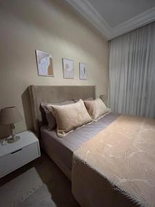 a bedroom with a bed and a table with a lamp at formidable S2 près du carrefour in La Marsa