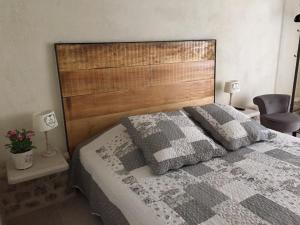 a bedroom with a bed with a wooden headboard at Le Petit Paradis in Honfleur