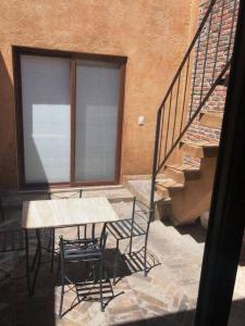 patio con tavolo, sedie e scale di Val’quirico - MONTALCINO 2 a Santeagueda