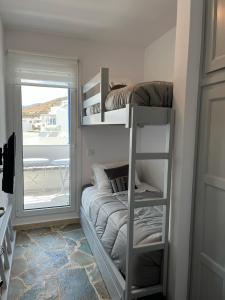 a room with two bunk beds with a window at Sea views - Marble Palace - 2 floors in Tinos Town