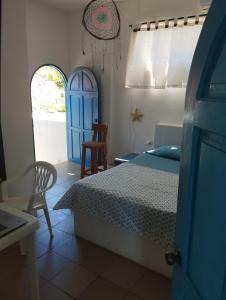 - une chambre avec un lit et une porte bleue dans l'établissement Luna del Mar, à San Silvestre