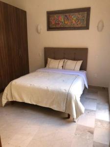 una camera da letto con un letto e un dipinto sul muro di Val’quirico - MONTALCINO 2 a Santeagueda