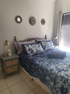 a bedroom with a bed with a blue comforter at Tranquility in Bloemfontein